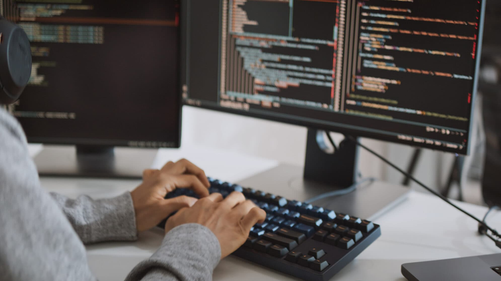 Software developer coding on a desktop computer